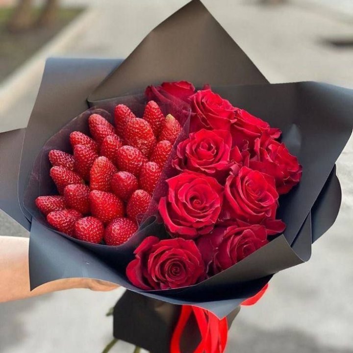 Round hat box holding chocolate covered strawberries arranged with roses