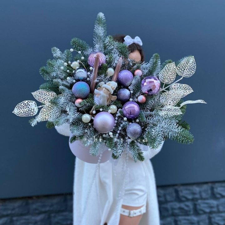 Low winter arrangement with fir, cones and red roses on a table